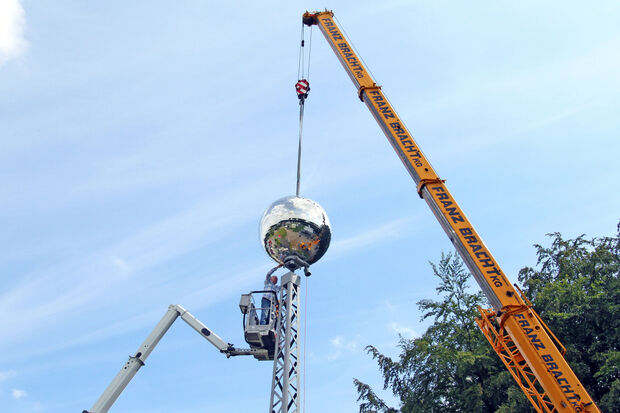 Werner Severin montiert die riesige Kugel mit Hilfe von Autokran und Hubwagen auf den Gittermast. FOTO: ANDREAS DUNKER
