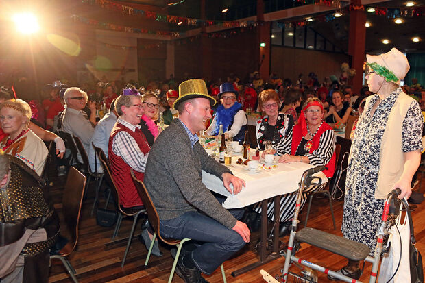 "Käthe aus Wiehagen" (Gudrun Arndt) mit ihrem "Wägelsken" (Rollator) am Tisch mit den Ehrengästen. Darunter Pfarrer Thomas Metter mit Mutter und die stellvertretende Bürgermeisterin Gertrud Martin (CDU), die den erkrankten Dr. Martin Michalzik (CDU) ersetzte. FOTO: ANDREAS DUNKER