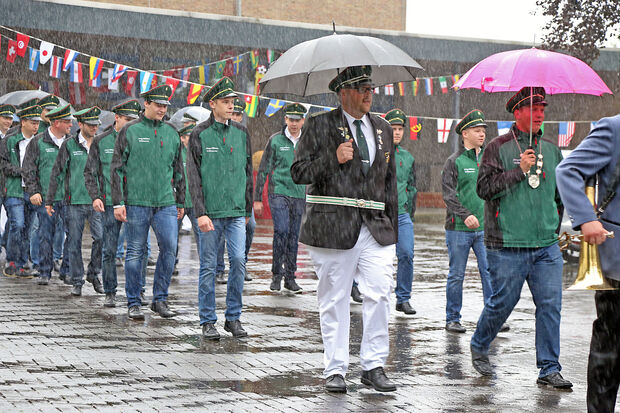 Beim Antreten an der ehemaligen Westerheideschule und dem Marsch von dort zur Gemeindehalle gab es Dauerregen. Vorne im Bild: der alte Jungschützenkönig Christopher Horn mit rosa Schirm. Links daneben: Jungschützenoffizier Tobias Belz – ebenfalls mit Schirm. FOTO: ANDREAS DUNKER 