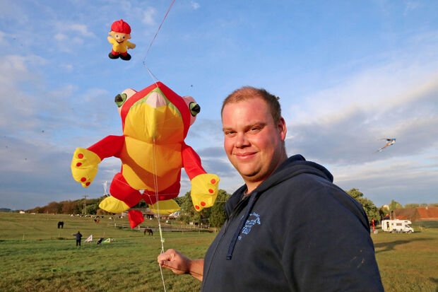 Lenkdrachen-Pilot Christpher Wilser (32) aus Fröndenberg mit einem riesigen Frosch und einem Mainzelmännchen. FOTO: ANDREAS DUNKER