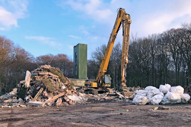 Bei den Abbrucharbeiten im ehemaligen Militär-Camp im Werler Stadtwald wird auch ein Langarmbagger mit einer besonders großen Reichweite eingesetzt. Im Hintergrund das alte Fernwärme-Heizkraftwerk für die drei Camps beiderseits der Bundesstraße 63.   FOTO: ANDREAS DUNKER