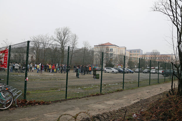 Die nach dem Brandalarm im Gebäude ins Freie evakuierten Flüchtlinge auf dem Gelände vor dem ehemaligen Marien-Krankenhaus FOTO: ANDREAS DUNKER