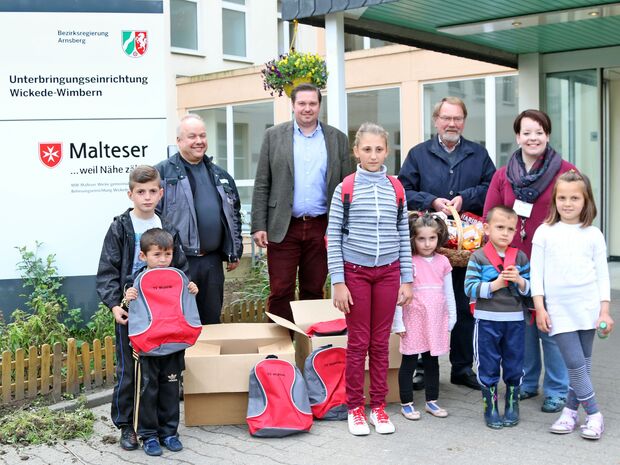 Spendenübergabe an der Massenunterkunft für Flüchtlinge in Wimbern. Hinter den Flüchtlingskindern stehen: Markus Thurau vom Turnverein Wickede (Ruhr), Lars Kern als künftiger neuer stellvertretender Einrichtungsleiter, Heinz Vihrog vom Freundeskreis "Menschen helfen Menschen" und  eine weitere Mitarbeiterin der Malteser-Werke (von links). FOTO: CARINA WESTERWELLE