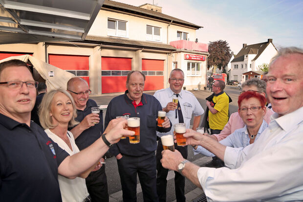 Nachbar Gerhard Hackethal (rechts) spendierte bei der "Sp(r)itzen-Fete" am Feuerwehr-Gerätehaus erst einmal eine Runde Bier für einige ehrenamtliche Einsatzkräfte und ihre Partnerinnen. FOTO: ANDFREAS DUNKER