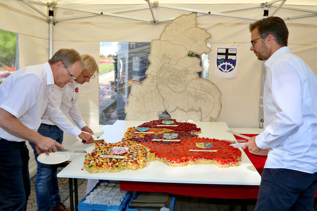 Bürgermeister Dr. Martin Michalzik (CDU) zusammen mit den Brüdern Hermann und Martin Niehaves (von links) beim Anschnitt des Geburtstagskuchens beim Bürger-Fest in der Wickeder Ortsmitte FOTO: ANDREAS DUNKER