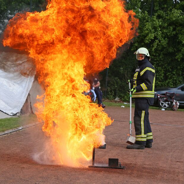 Stichflamme beim Löschen eines Fettbrandes mit Wasser – im Hintergrund: Feuerwehrmann Hermann Boivin FOTO: ANDREAS DUNKER